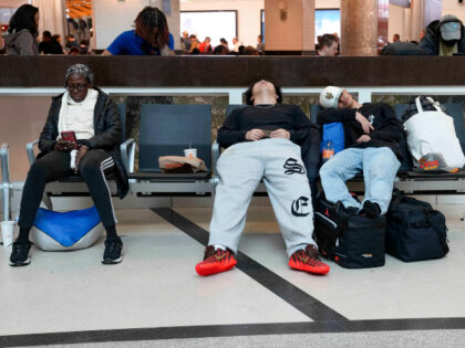 Travelers sleep in chairs at Hartsfield-Jackson Atlanta International Airport on March 16,