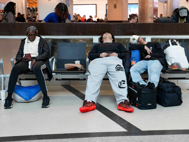 Travelers sleep in chairs at Hartsfield-Jackson Atlanta International Airport on March 16,
