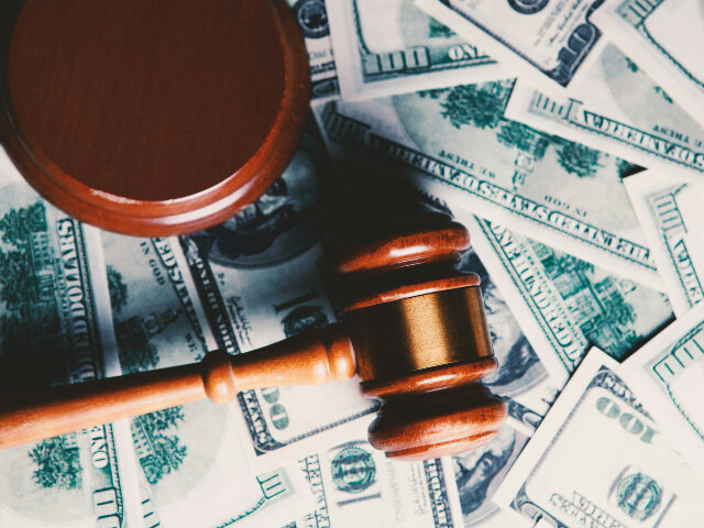 Gavel lying on hundred dollar bills