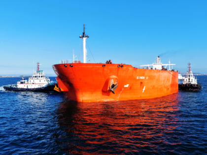 An oil tanker carrying imported crude oil, assisted by a tugboat, sails towards the crude