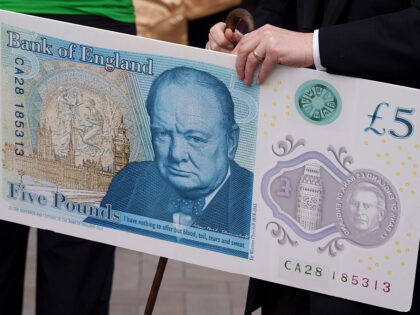 A member of staff from the the Bank of England holds a specimen £5 bank note featuring Si