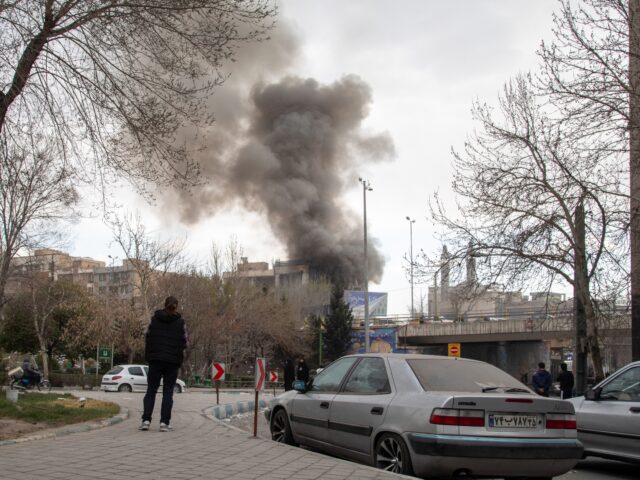 TEHRAN, IRAN - MARCH 2: A person watches as a plume of smoke rises after an explosion on M
