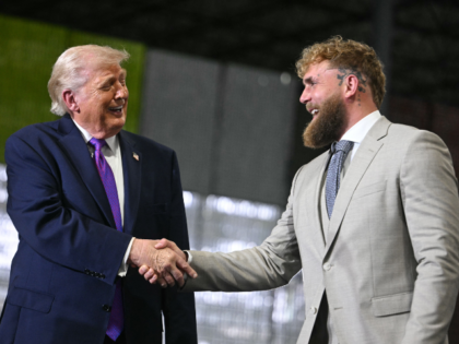 US President Donald Trump shakes hands with US boxer and influencer Jake Paul during a ral
