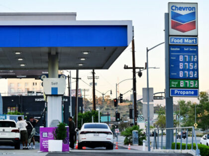 The sign of a Chevron gas station displays current prices as drivers pump gas in Rosemead,