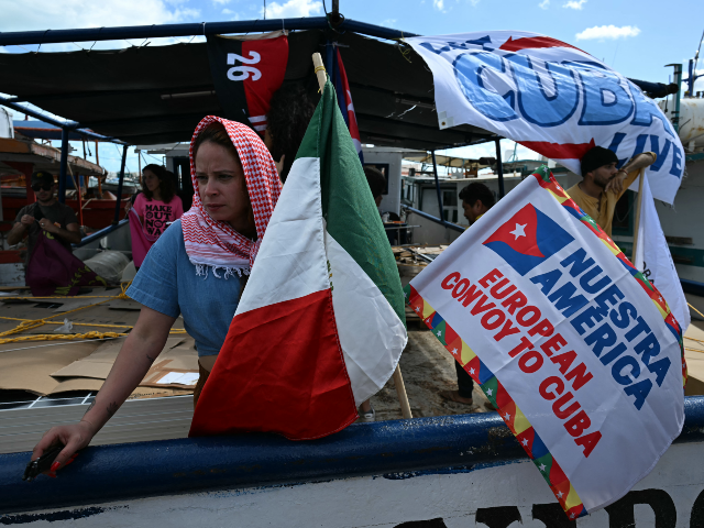 An activist of NuestraAmerica Iniciative looks on next to a Mexican flag on a boat nicknam