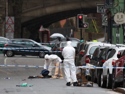 Police forensic officers fill evidence bags while working amongst a variety of personal it