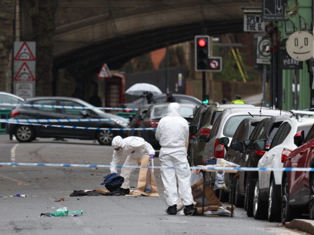 Police forensic officers fill evidence bags while working amongst a variety of personal it