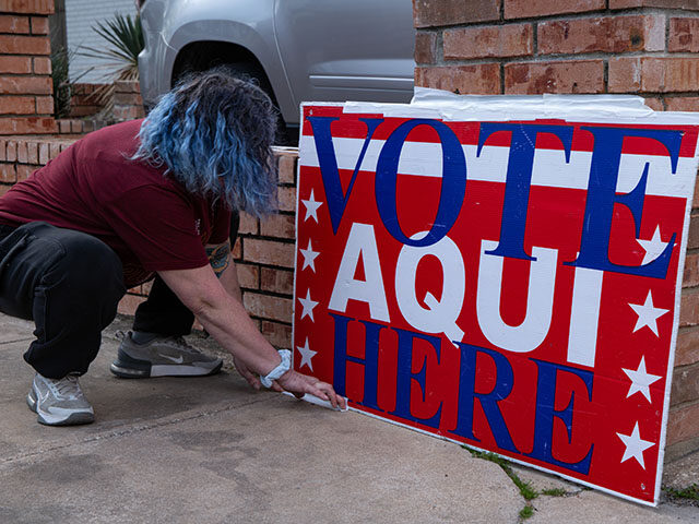 A worker sets up a "Vote Here" sign at the Mary Lee Foundation polling location during the