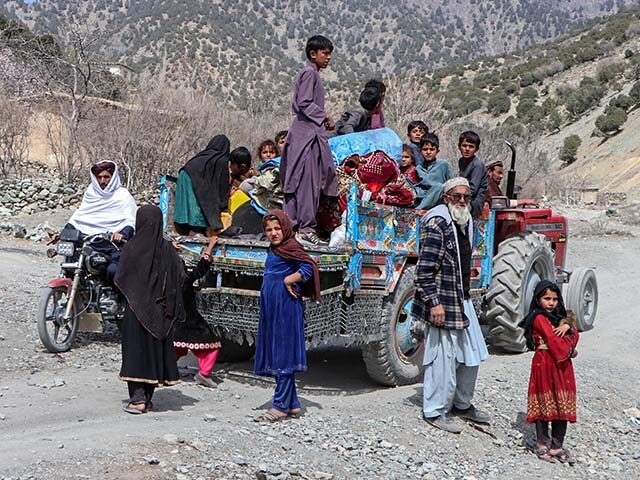 Afghan families along with children escape from the area amid the ongoing clashes between