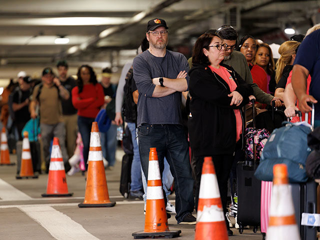Travelers wait in line at a Transportation Security Administration (TSA) checkpoint at Wil