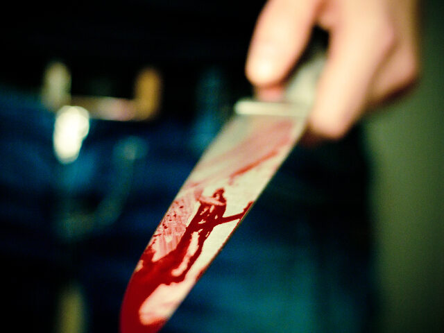 Hand holding bloody knife