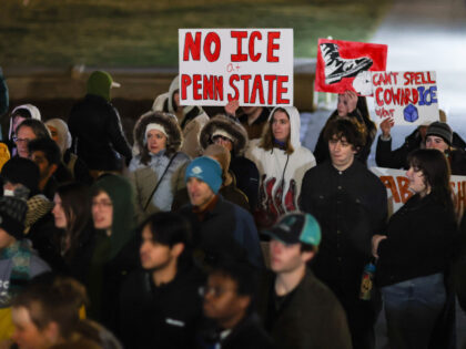 Demonstrators hold placards outside of Penn State's Old Main during a protest against U.S.