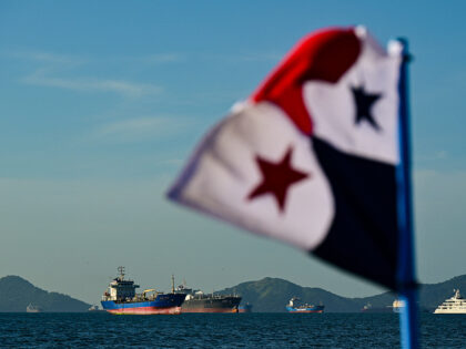 A Panamanian flag is pictured in front of cargo ships waiting to enter the Panama Canal in