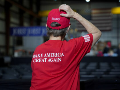 An attendee wears a "Make America Great Again" shirt and a "Trump" hat