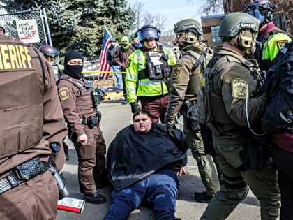 Activists are detained by law enforcement outside the Bishop Henry Whipple Federal Buildin