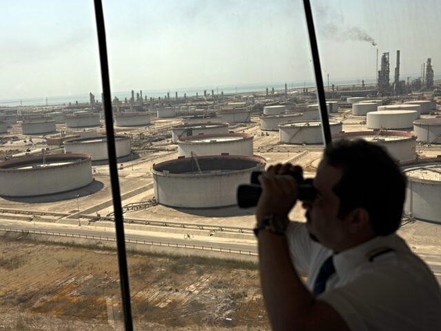 An employee uses binoculars to look out towards the Arabian Sea in the Port Control Center