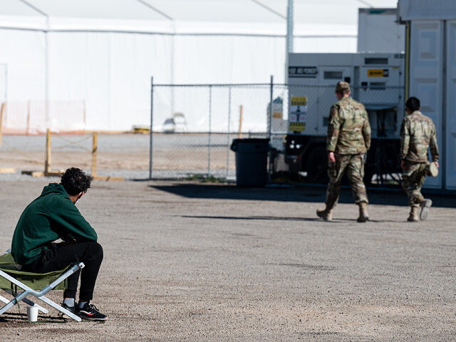HOLLOMAN AIR FORCE BASE, NM - NOVEMBER 04: An Afghan refugee sits and watches as US milita
