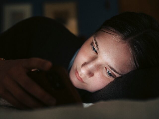 girl using social media in the dark