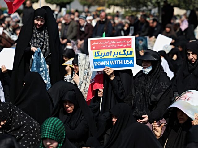 A woman holds an anti-US placard during Friday noon prayers at the compound of the Mosalla