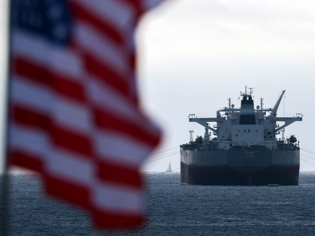 A US flag flutters in the wind as the CHIOS crude oil tanker sits anchored off the coast o