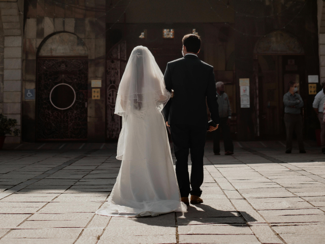 pexels-one-horizon-productions-114406467-9720087 Rear view of bride and groom at church