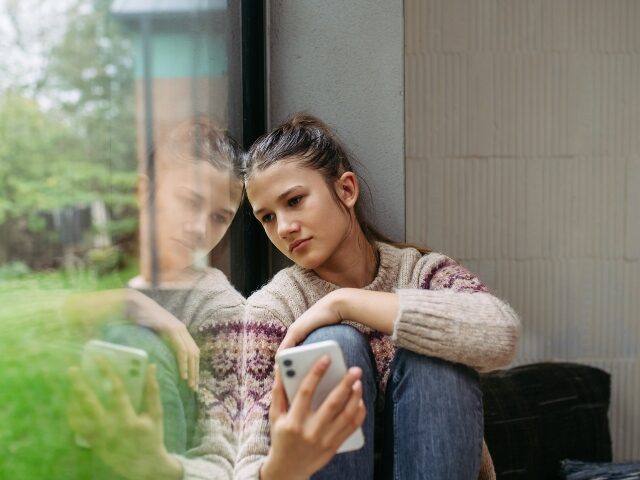 sad girl using her phone