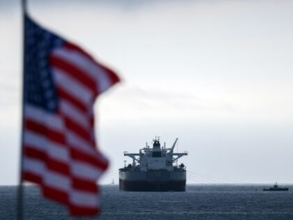 A US flag flutters in the wind as the CHIOS crude oil tanker sits anchored off the coast o