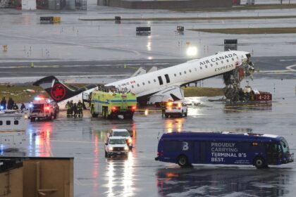 An Air Canada Express CRJ-900 sits on the runway after colliding with a Port Authority fir