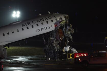 An Air Canada Express CRJ-900 sits on the runway after colliding with a Port Authority fir