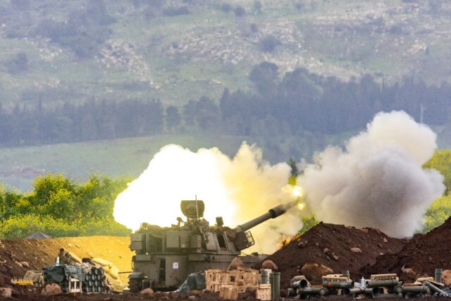 An Israeli self-propelled howitzer artillery gun fires rounds toward southern Lebanon
