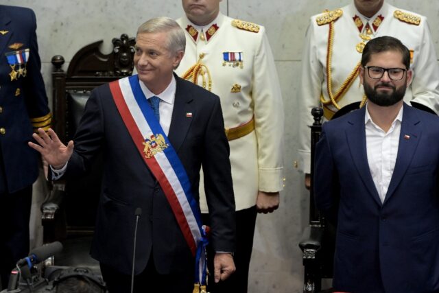 Chilean President Jose Antonio Kast (L) waves at his inauguration as he stands next to out