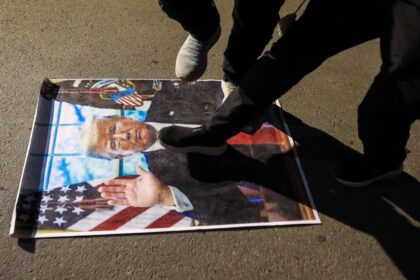 Demonstrators against the war in Iran trample on a portrait of US President Donald Trump d