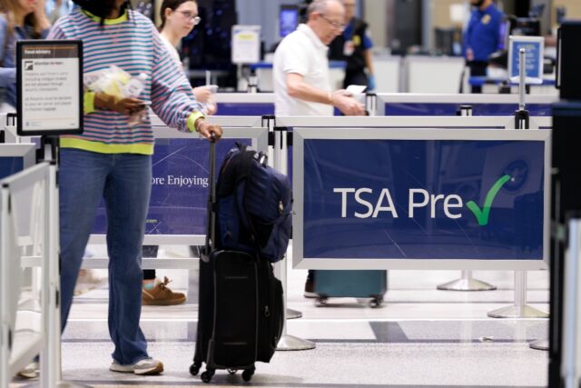 People wait in line at a TSA security checkpoint at William P. Hobby Airport in Houston, T