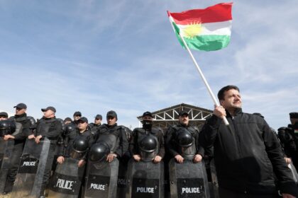 A protester holds a Kurdish flag at a demonstration outside the United Nations office in A