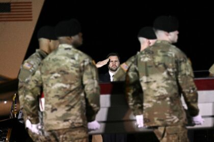 US Vice President JD Vance salutes as members of a US Army team carry a flagged-drapped tr