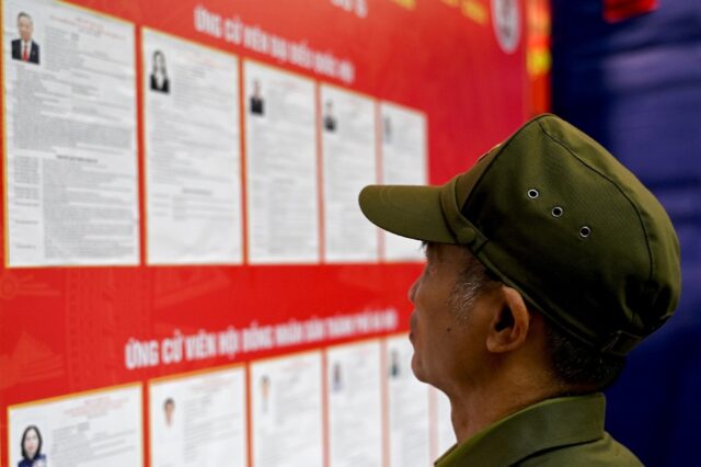 A man views the list of candidates for the upcoming National Assembly and local People