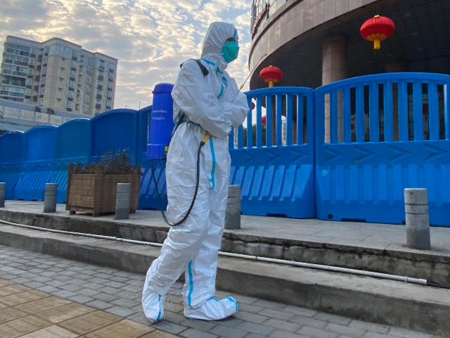 FILE - In this Feb. 6, 2021, file a worker in protectively overalls and carrying disinfect