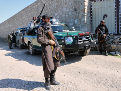 Taliban police guard the area where a strike hit a house in the Momand Dara district of Na