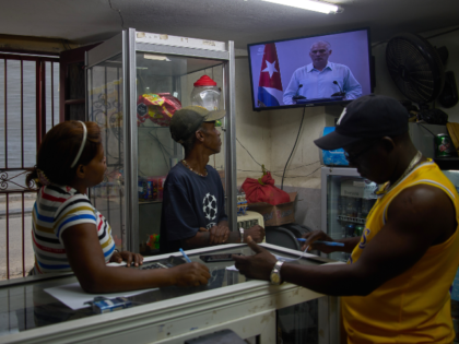 People inside a private convenience store see Cuban President Miguel Diaz-Canel speaking o