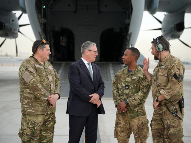 Britain's Prime Minister Keir Starmer speaks to members of the aircrew before boardin