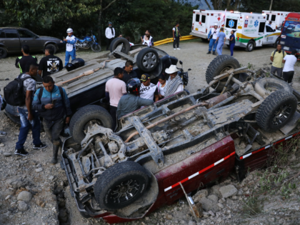 People stand among vehicles damaged in an attack on the Pan-American Highway in Cajibio, C