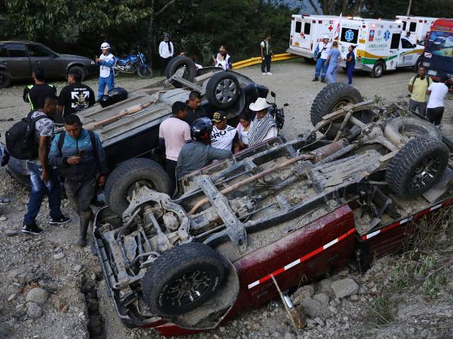 People stand among vehicles damaged in an attack on the Pan-American Highway in Cajibio, C