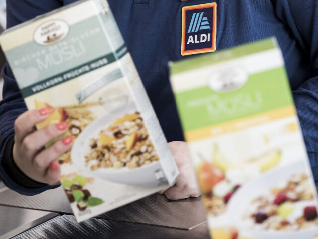 An employee scans a box of muesli cereal at the check out inside an Aldi Stores Ltd. groce