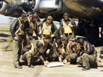 Gathered around the map of their target, in front of their plane, are the crew of the "But
