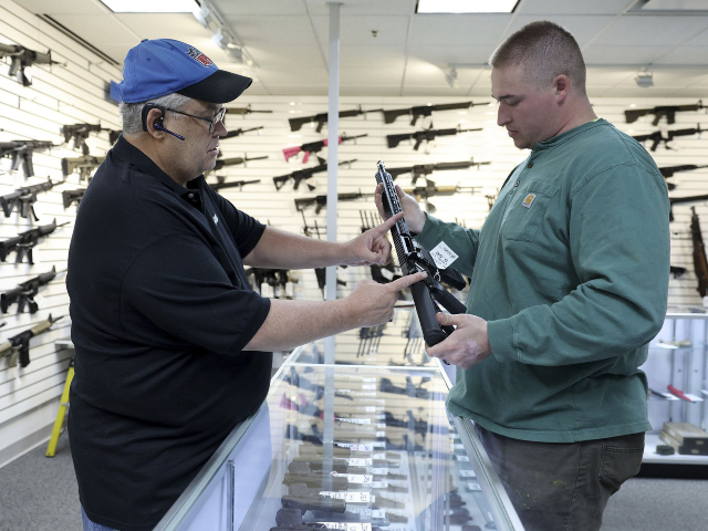 Roger Krahl, president of RGuns, left, gives information to Zack Johnson about an RGuns-br