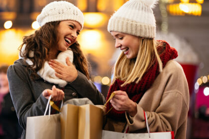 Happy women friends are shopping for presents at Christmas. People xmas holiday sale shopp