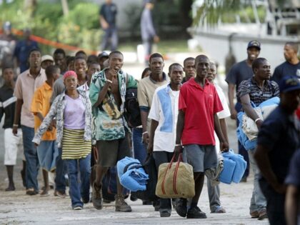 Haitian refugees line up moments after they were repatriated to Haiti, dropped off at the