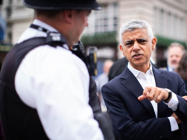 Mayor of London Sir Sadiq Khan speaks with police officers during a walkabout in the West
