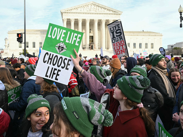 People hold "Love Life - Choose Life" signs in front of the US Supreme Court as they march