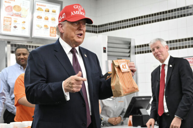 US President Donald Trump holds a bag of food in a Whataburger restaurant in Corpus Christ